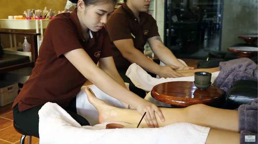 young thai massage foot therapist